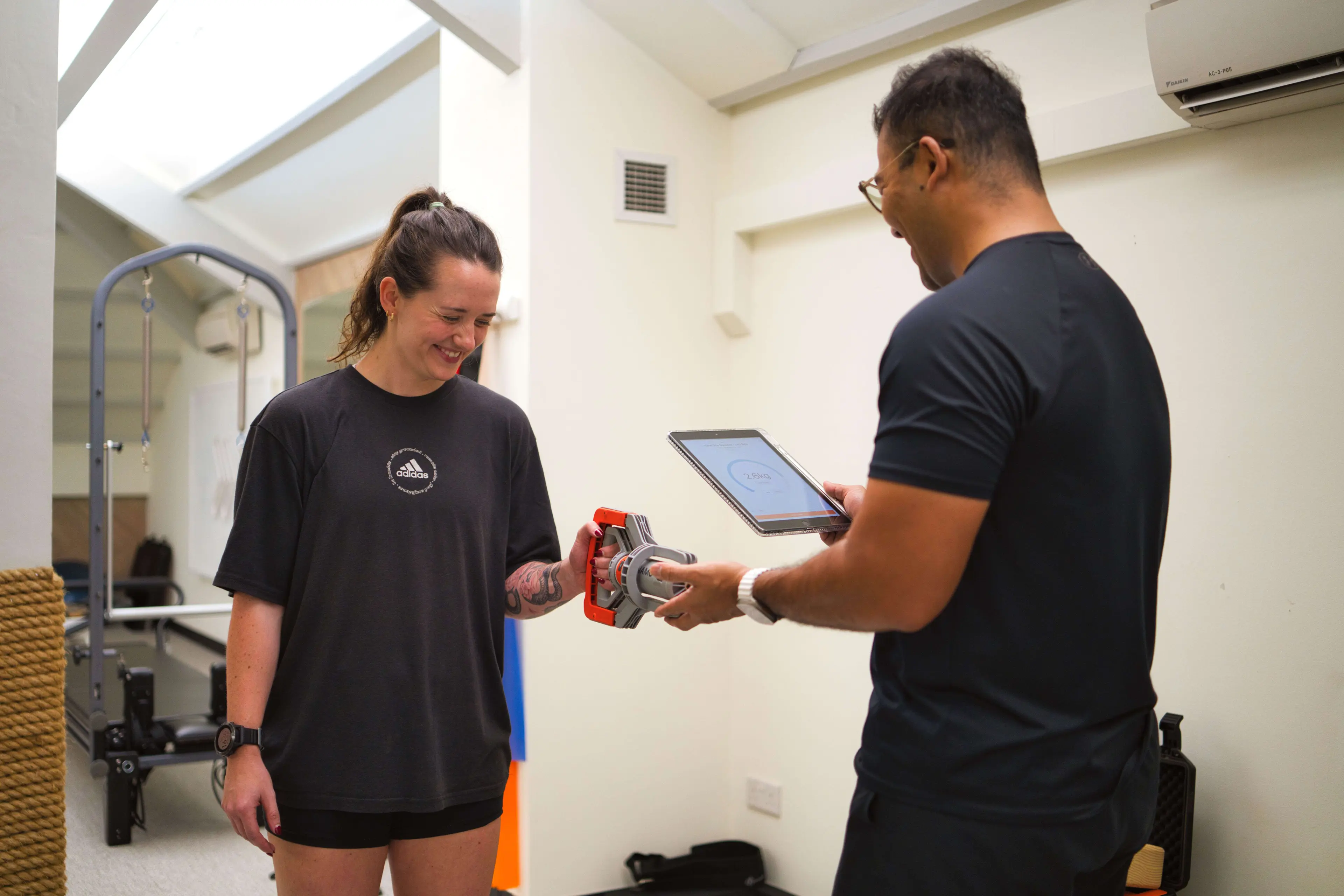 UFIT Client and Practitioner performing grip assessment on DynaMo Plus.